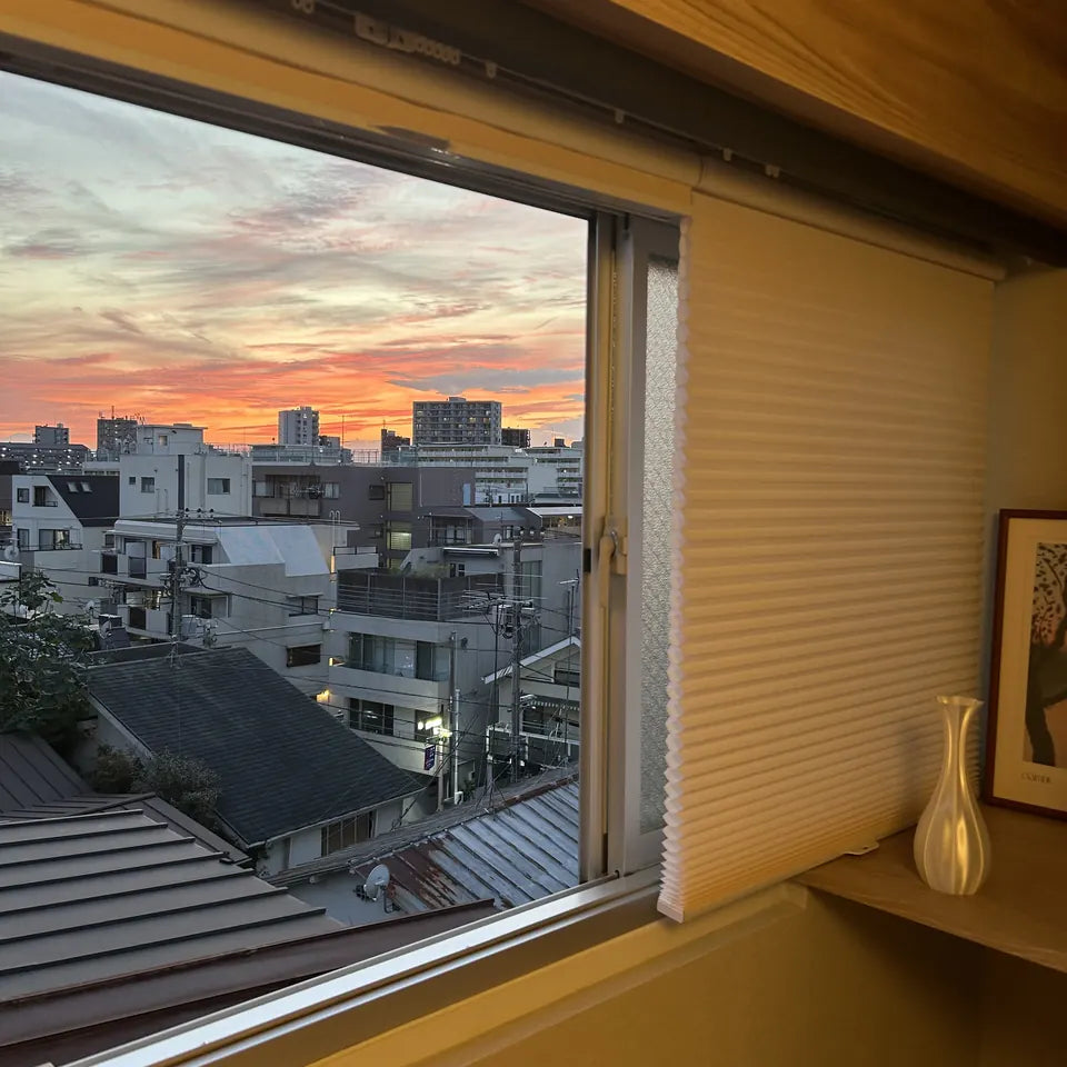 夕景の窓辺に設置されたハニカムシェード
